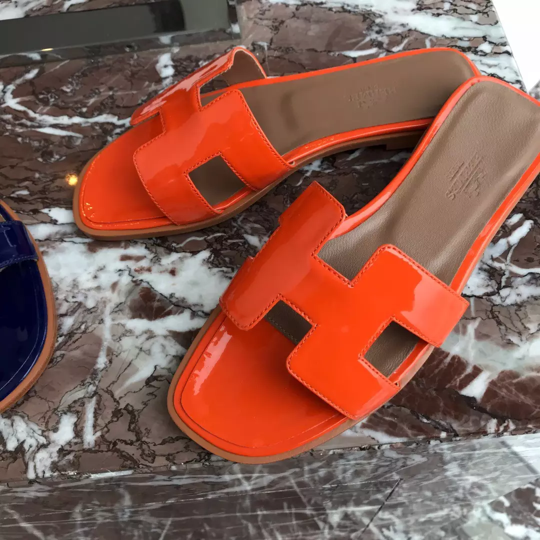 HERMES ORAN SLIDE SANDALS IN ORANGE PATENT CALFSKIN - HMSD085